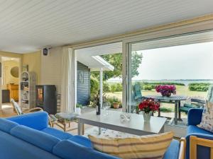 KragenæsHoliday Home Eddy - all inclusive - 50m from the sea by Interhome的客厅配有蓝色的沙发和桌子