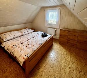 特尔乔夫Chata Barborka的一间卧室配有一张床、一个梳妆台和一扇窗户。