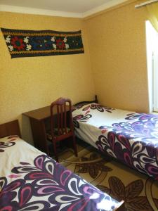 杜尚别Sayfi Guesthouse的一间卧室配有两张床、一张桌子和一把椅子