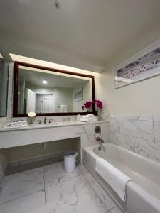 那不勒斯The Capri Inn的白色的浴室设有浴缸和大镜子