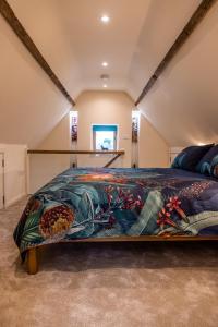 坎特伯雷The Stable的一间卧室配有一张大床和色彩缤纷的毯子