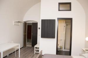 鲁沃迪普利亚B&B Cemener的一间设有白色墙壁、桌子和橱柜的房间