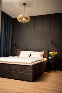 弗罗茨瓦夫Apartament No1 Wyszyńskiego的一间卧室设有一张床和黑色的墙壁