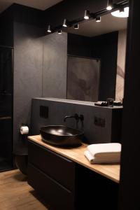 弗罗茨瓦夫Apartament No1 Wyszyńskiego的黑色浴室设有水槽和镜子