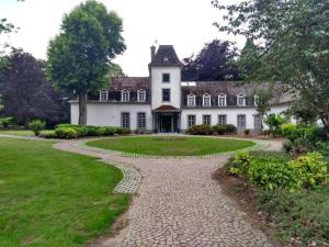 胡塔伦De Bosdreef - Hengelhoef - duplex met verwarmd openluchtzwembad的一条通往白色大房子的鹅卵石路径
