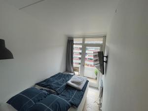哥本哈根Central Apartment with Balcony & Free Parking的一间小卧室,配有床和窗户