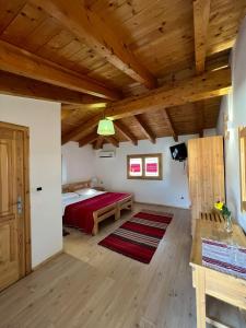 莱什Mrizi i Zanave Agroturizëm的一间卧室设有红色的床和木制天花板