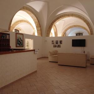 阿莱萨诺科利布瑞酒店的大客房设有拱形天花板、沙发和电视。