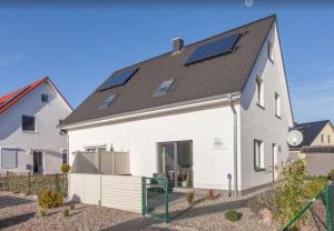 齐罗Ferienhaus Wellenreiter的屋顶上设有太阳能电池板的白色房子