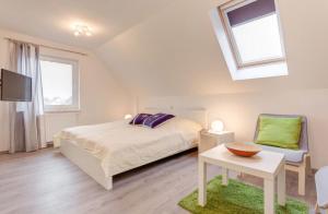 齐罗Ferienhaus Wellenreiter的一间卧室配有一张床、一台电视和一把椅子