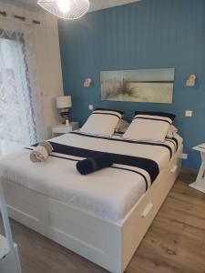 滨海埃尔芒维尔Studio les jardins de la brèche的一间卧室配有一张带蓝色墙壁的大床