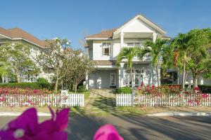 潘切Casa Villa - Ocean View - Sealinks City Resort的白色的栅栏和鲜花的房子