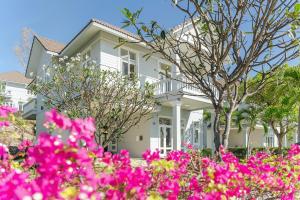 潘切Casa Villa - Ocean View - Sealinks City Resort的前面有粉红色花的白色房子