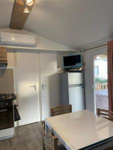 鲁西隆地区卡内Mobil home 6 à 8 personnes Sans Fun Pass的厨房配有白色台面和冰箱