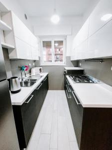 科莱尼奥MYHOUSE INN SUITE PARADISO - Affitti Brevi Italia的白色的厨房设有水槽和炉灶。