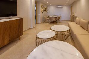 马拉喀什Appartement luxueux Coralia avec piscine的客厅配有两张桌子和一张沙发