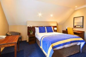 瓦灵福德乔治酒店的配有一张床和一张书桌的酒店客房