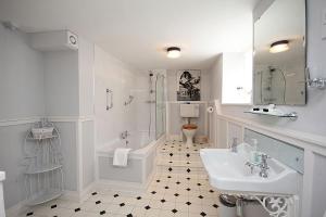 邓斯特Dunster Mill House的白色的浴室设有水槽、浴缸和卫生间。