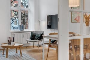 哥本哈根NABO Hotel Apartments的客厅配有桌椅和电视。