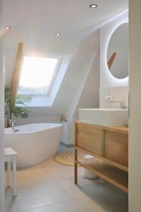 弗罗伊登施塔特Helles modernes City-Loft的浴室配有白色浴缸和水槽
