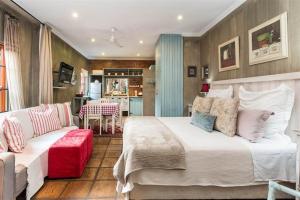 比勒陀利亚Ambiance Guesthouse的一间卧室配有一张大床和一张沙发