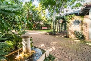 比勒陀利亚Ambiance Guesthouse的庭院中间带喷泉的花园