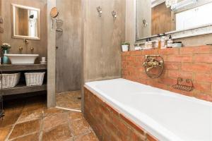 比勒陀利亚Ambiance Guesthouse的带浴缸和盥洗盆的大浴室
