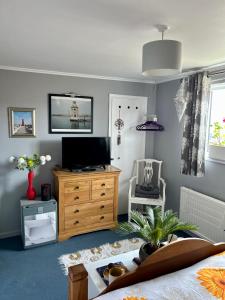 康斯坦丁Double bedroom Helford central Cornwall的一间带木制梳妆台的电视的卧室