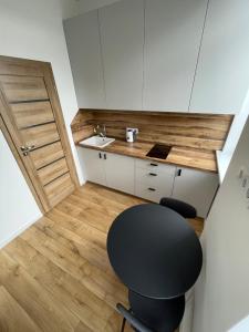 维尔纽斯Airport Apartment 32 self check-In Free Parking的一个带黑椅子和水槽的小厨房