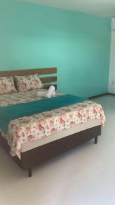 伊塔齐米林Pousada Ilha de Itacimirim的一间卧室配有一张带鲜花的大床