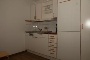 BräckeHusHotellHunge AB的厨房配有白色橱柜和冰箱。