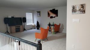 弗雷德里克528 Carroll Walk Avenue的客厅配有橙色椅子和电视