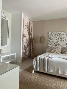 阿雷斯Chambres d'Hôtes Villa La Louisiane的白色卧室配有床和镜子
