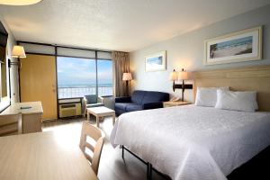 默特尔比奇Holiday Sands North "On the Boardwalk"的酒店客房配有一张床、一张桌子和一把椅子。