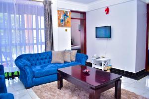 基苏木Rozy Penthouse的客厅配有蓝色的沙发和茶几