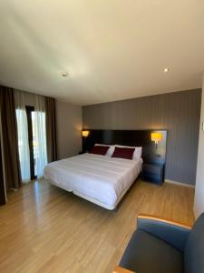 布拉内斯珀蒂帕劳酒店 - 仅限成年人的卧室配有一张白色的大床和一张沙发。