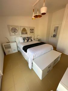 圣港Golden Beach House的卧室配有白色大床和白色桌子
