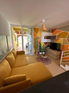 圣港Golden Beach House的客厅设有黄色沙发和电视