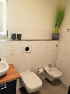 阿尔特费尔Ferienwohnung MeerZeit EG的白色的浴室设有卫生间和水槽。