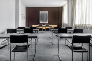 萨莫拉萨莫拉生活方式万豪AC酒店的一间设有桌椅的会议室和一幅画