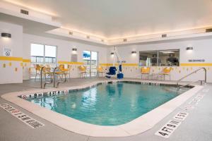 弗雷德里克斯堡Fairfield Inn & Suites by Marriott Fredericksburg Texas的一座大型游泳池,位于一座带黄色椅子的建筑内