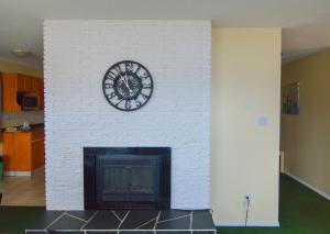 彭蒂克顿海岸线度假公寓汽车旅馆的白色砖砌壁炉,上面有时钟