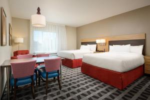 塔斯卡卢萨TownePlace Suites by Marriott Tuscaloosa的酒店客房带两张床和一张桌子以及椅子。