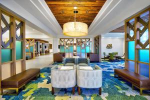 奥兰多Fairfield by Marriott Inn & Suites Orlando at FLAMINGO CROSSINGS® Town Center的酒店大堂设有长沙发、椅子和吊灯。