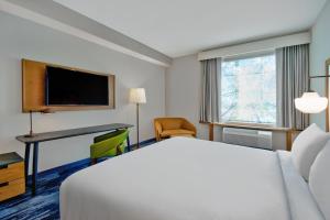 奥兰多Fairfield by Marriott Inn & Suites Orlando at FLAMINGO CROSSINGS® Town Center的酒店客房配有一张床、一张书桌和一台电视。
