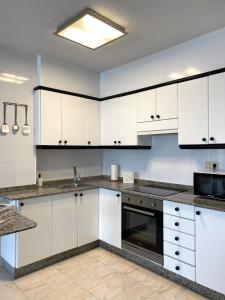蒙福特·德·莱蒙斯Lemos Estrella的厨房配有白色橱柜和水槽