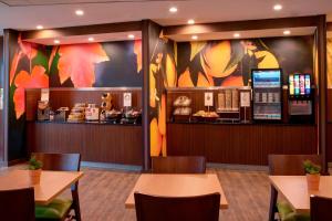 伊普西兰蒂Fairfield Inn & Suites By Marriott Ann Arbor Ypsilanti的一间带桌椅和柜台的餐厅