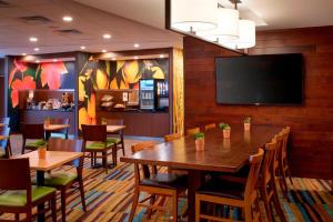 伊普西兰蒂Fairfield Inn & Suites By Marriott Ann Arbor Ypsilanti的餐厅设有桌椅和平面电视。