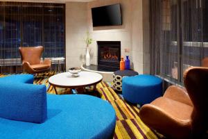 TriadelphiaFairfield by Marriott Inn & Suites Wheeling at The Highlands的客厅配有蓝色椅子和壁炉