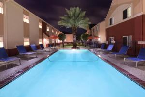 Clute杰克逊湖克鲁特万豪广场套房酒店的一个带椅子和棕榈树的大型游泳池
